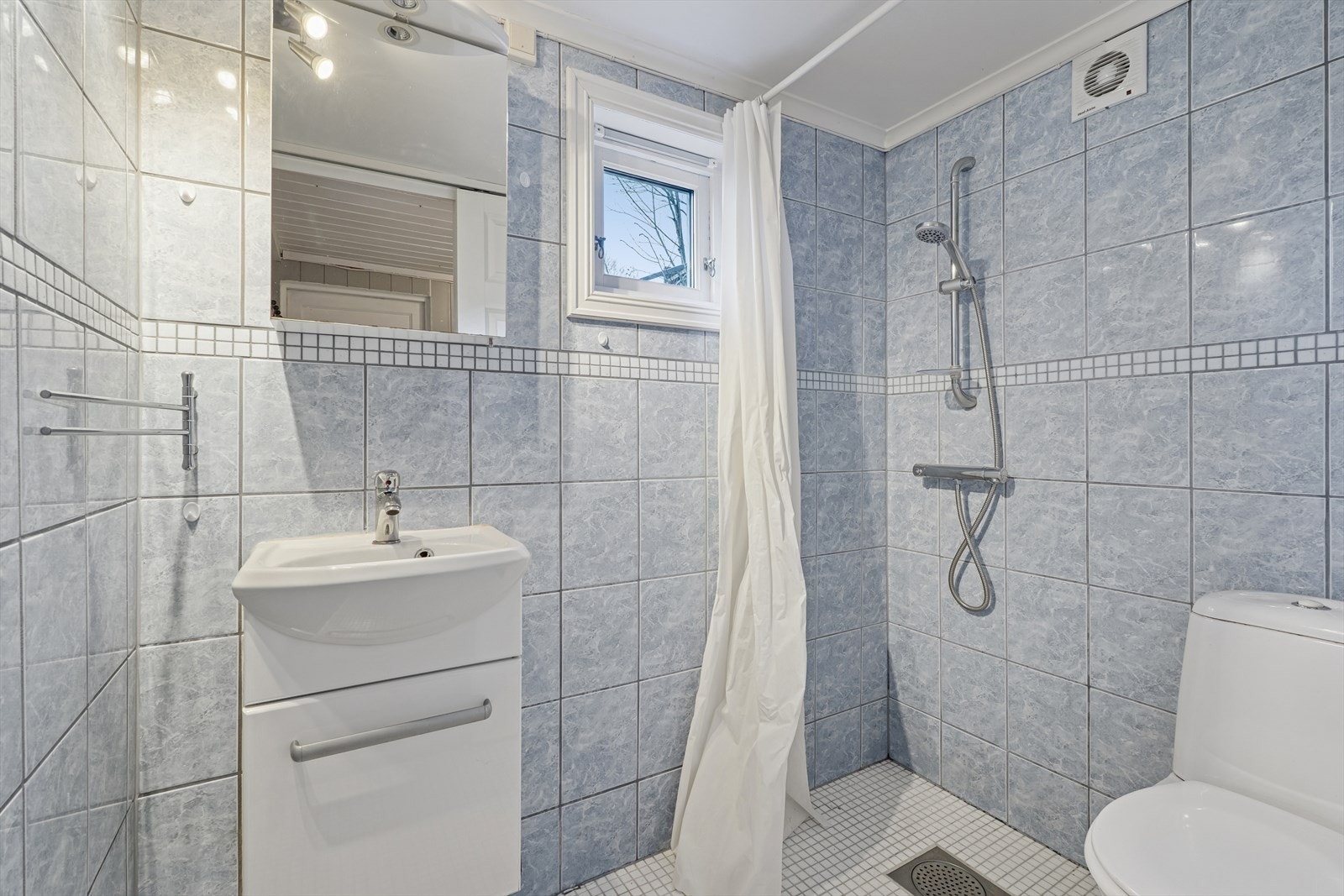 Rom i anneks innredet som bad, her er det fliser på vegg, og gulv. Galleribilde