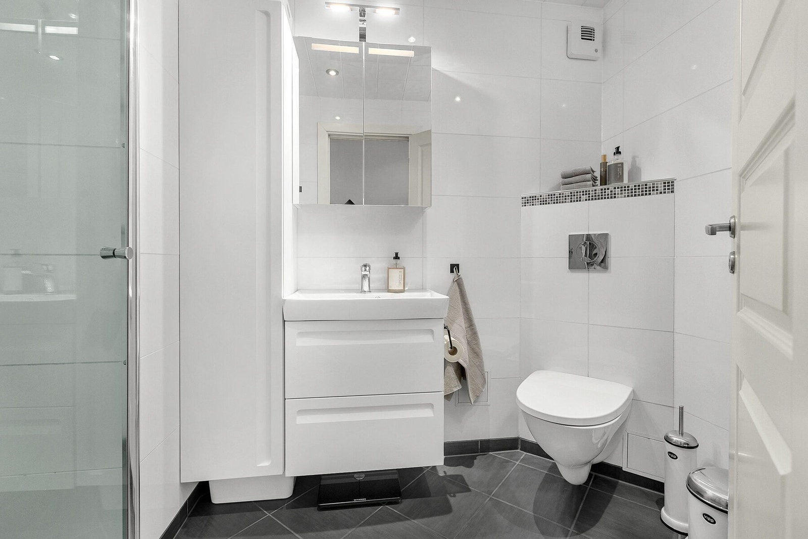 Helfliset bad med varme i gulv, dusjnisje og spotter i tak. Galleribilde