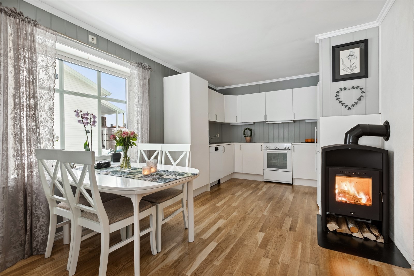 Kjøkken i kombinasjon med stue og med mulighet for spisebord. Innredningen framstår klassisk, med hvite, slette fronter, laminat benkeplate og frittstående hvitevarer. Galleribilde