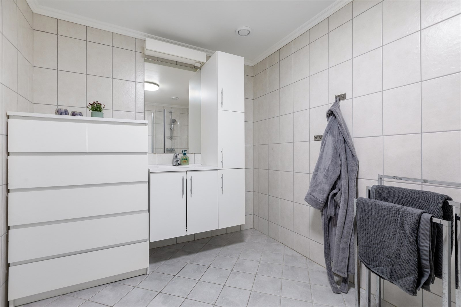 Baderom med flislagte gulv og vegger i tidløse fargetoner. Galleribilde