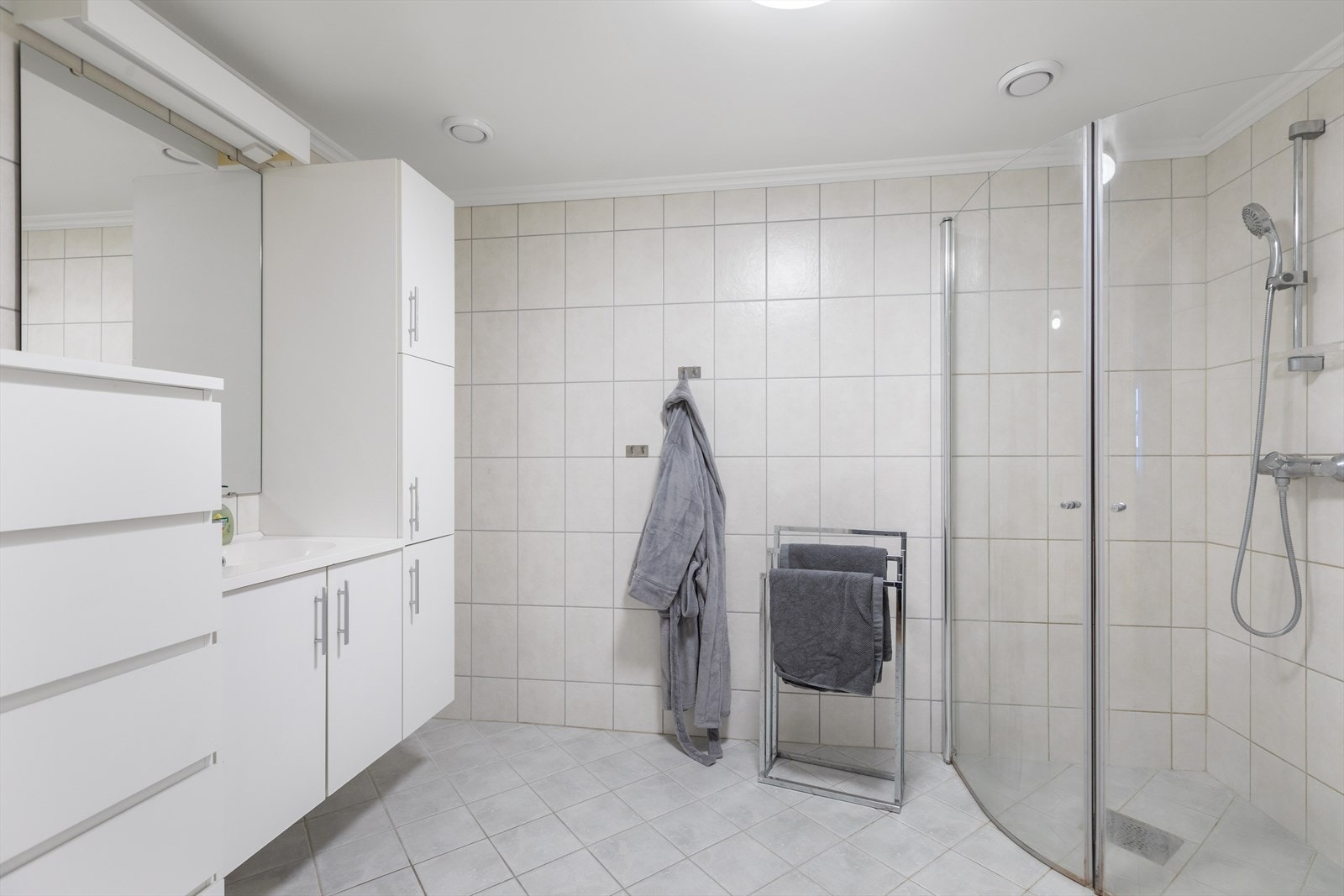 Badet er utstyrt med toalett, servant med skap og dusjhjørne med innfellbare glassdører. Galleribilde