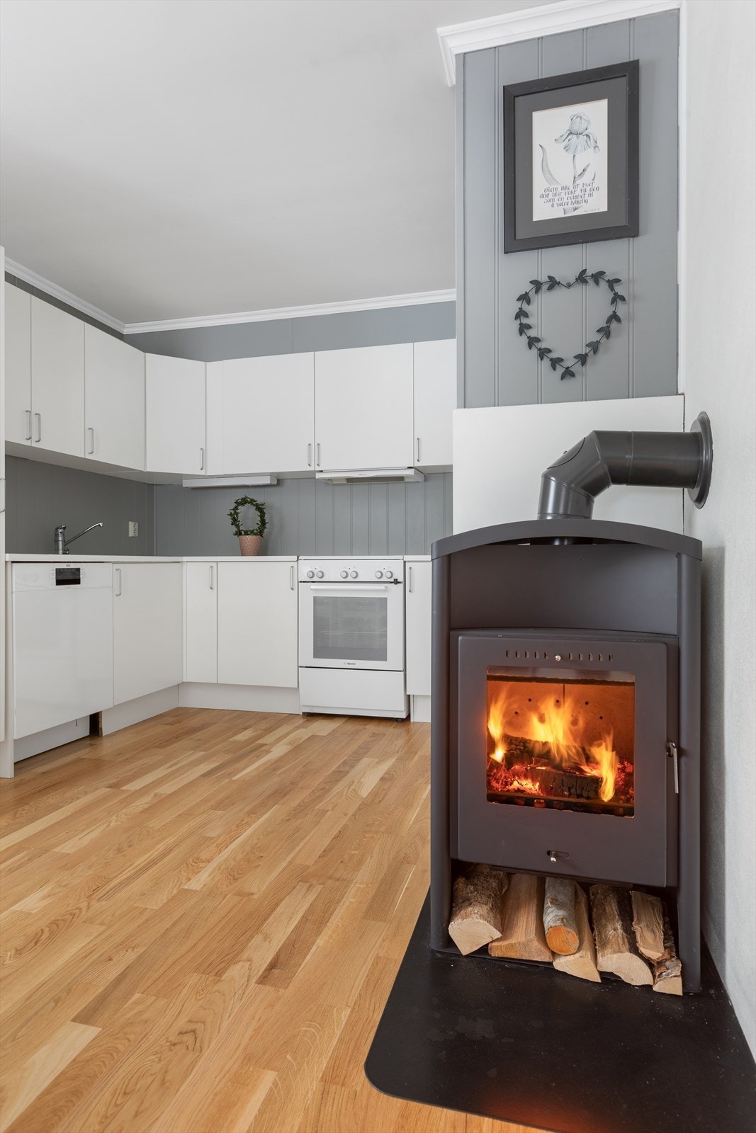 Midt i rommet er det montert en hyggelig peisovn, denne sikrer varme på kalde høst- og vinterkvelder. Galleribilde