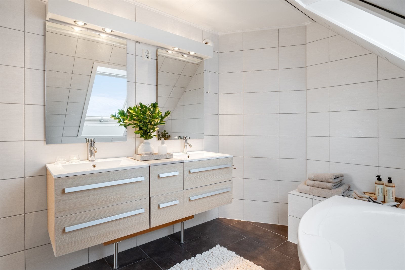 Badet (ikke omsøkt/godkjent) er helfliset og innredet med dobbelt servant, speil, belysning, toalett og boblebadekar. Varmekabler i gulv. Galleribilde