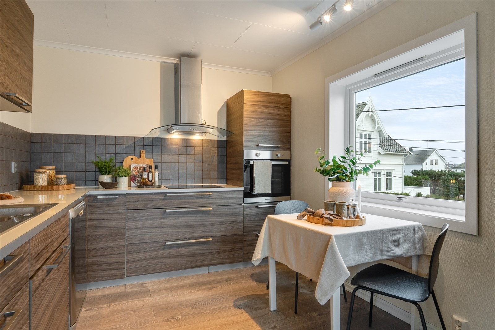 Stilrent kjøkken med glatte fronter og benkeplate av laminat med nedfelt vask. Galleribilde