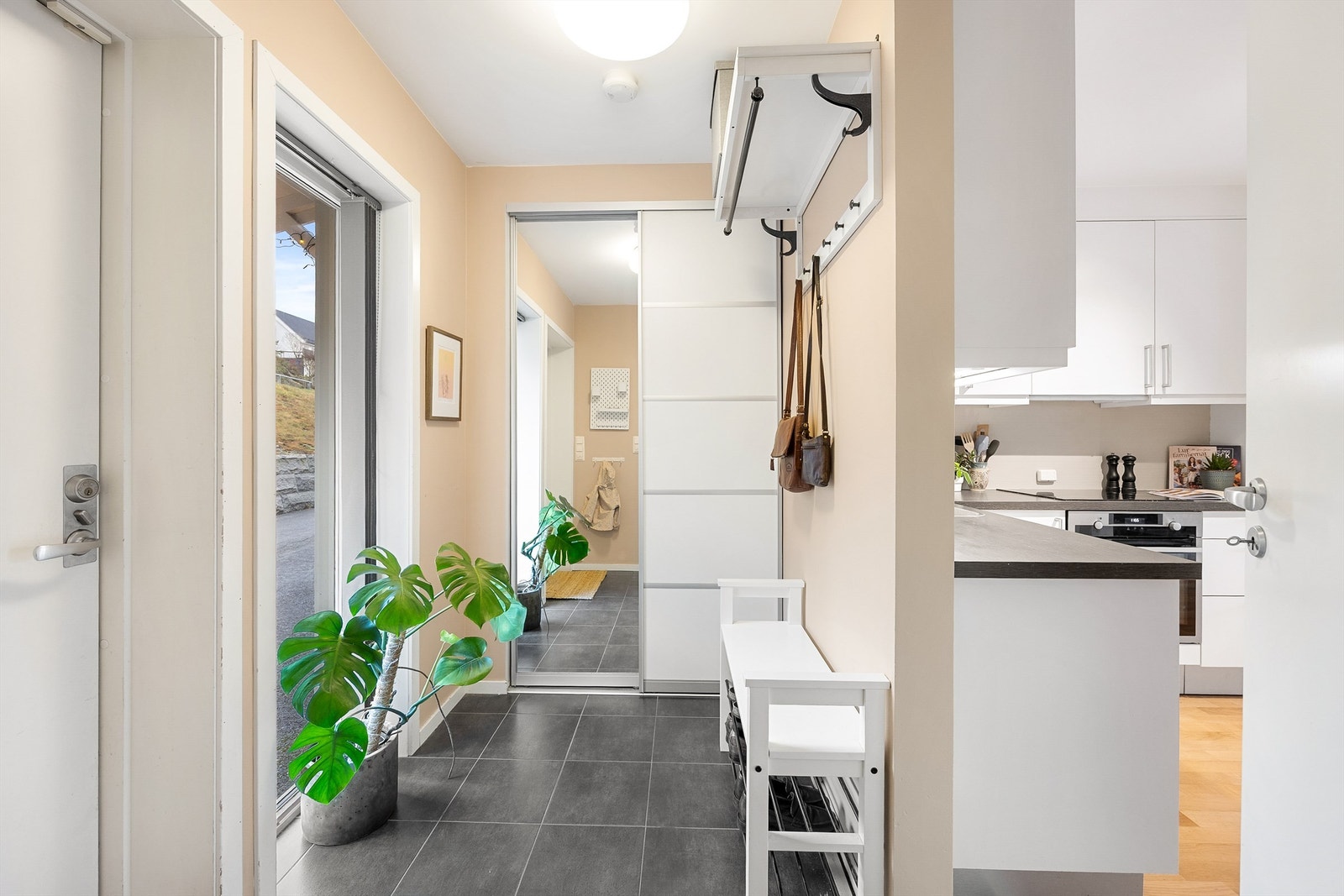 Flislagt entre med skyvedørsgarderobe for god oppbevaring av yttertøy Galleribilde