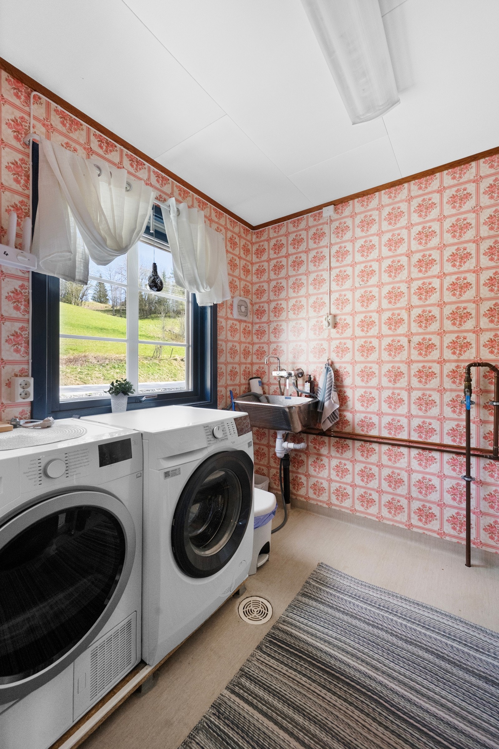 Praktisk vaskerom med opplegg for vaskemaskin, vaskekum og varmtvannsbereder. Galleribilde