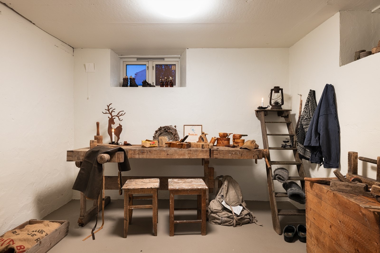 Arbeidsbenk og enkel innredning skaper et funksjonelt rom for hobbyaktiviteter Galleribilde