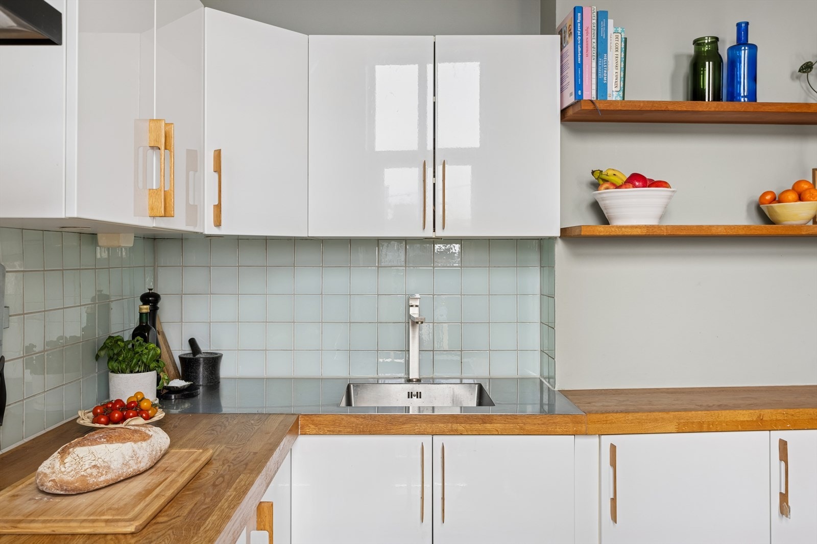 Gjennomført kjøkken med matchende håndtak i heltre. Galleribilde