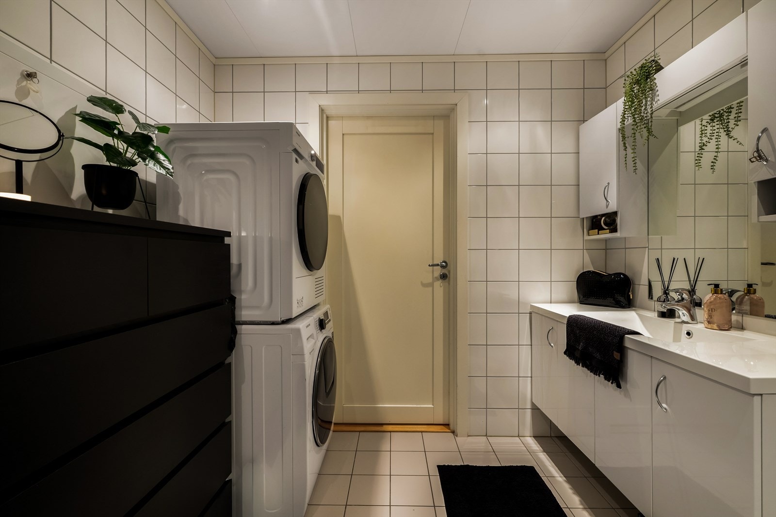 Badet i 1.etasje er innredet med veggmontert toalett, servantskap, veggskap, opplegg for vaskemaskin og dushjørne Galleribilde