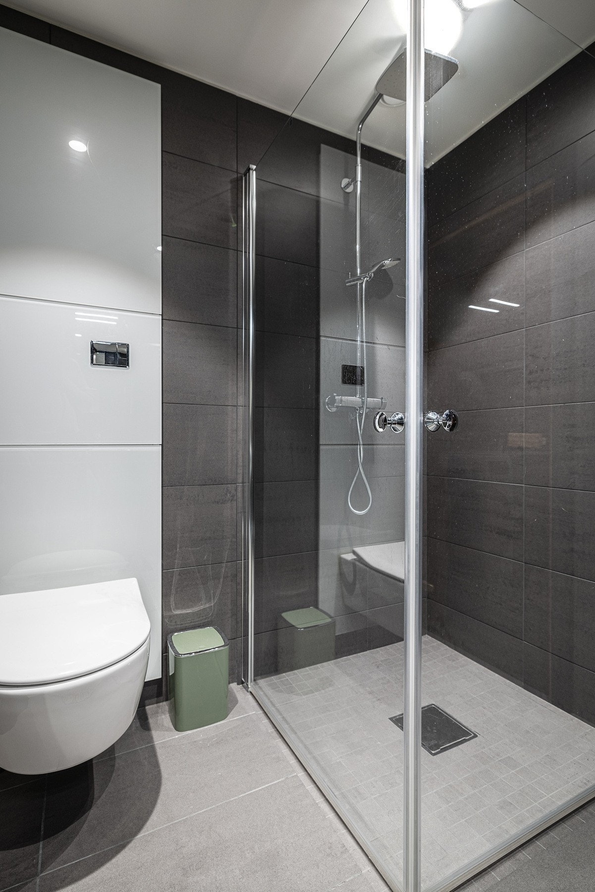 Badet er videre utstyrt med vegghengt toalett og en romslig dusjnisje med glassdører, hånddusj og regnfallsdusj. Galleribilde