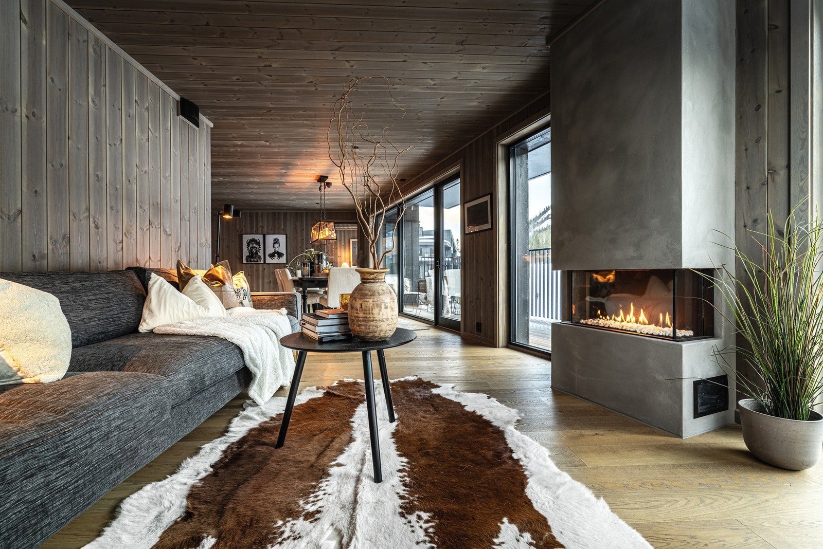 Rommets utforming gir naturlige soner for møblering, med god plass til sofagruppe foran gasspeisen, som både gir varme og skaper en hyggelig atmosfære. Det er også plass til stort spisebord i tilknytning til kjøkkenet. Galleribilde