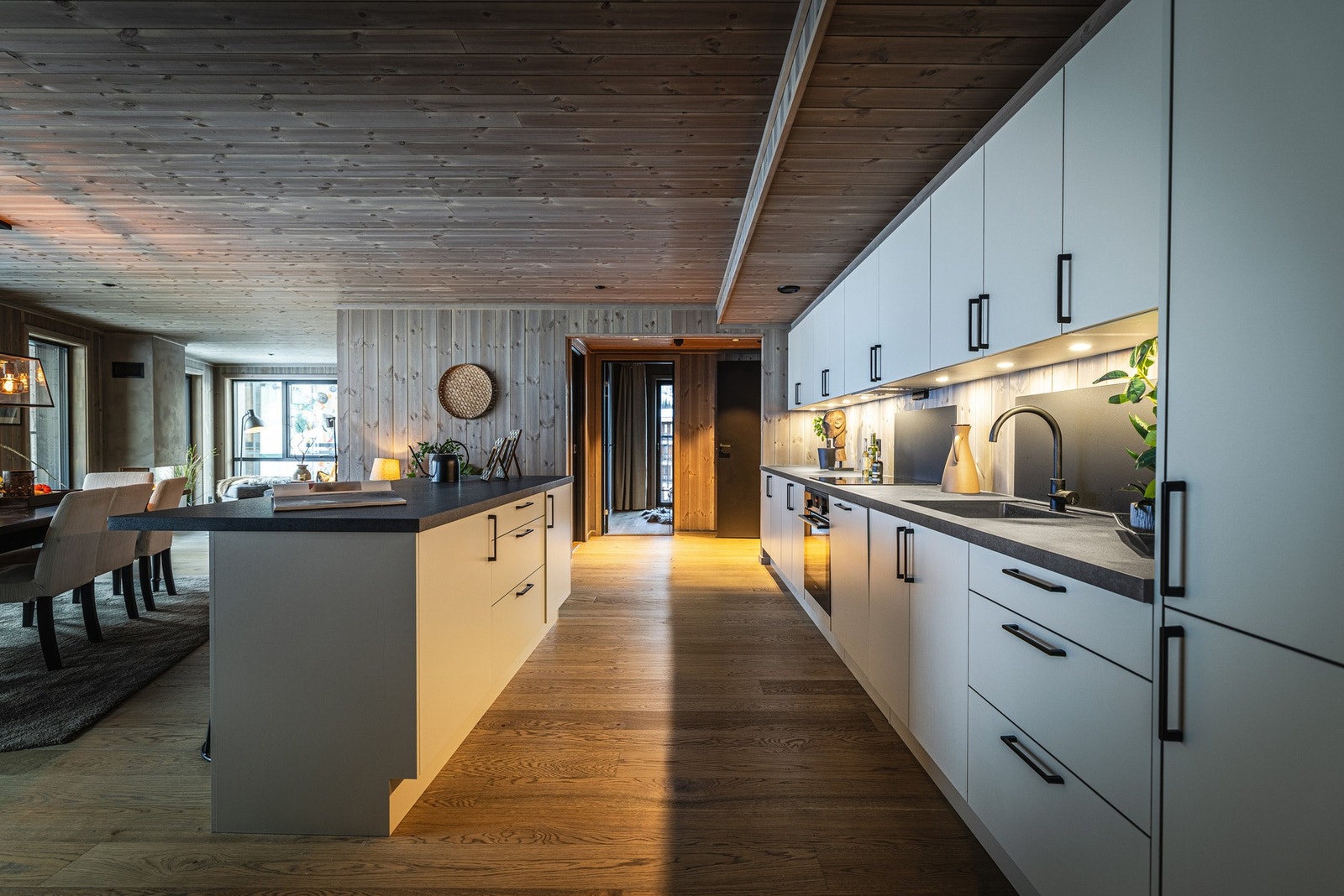 Stor kjøkkenøy med nisje for sitteplasser gir ekstra oppbevaringsplass og fungerer som et hyggelig samlingspunkt. Galleribilde