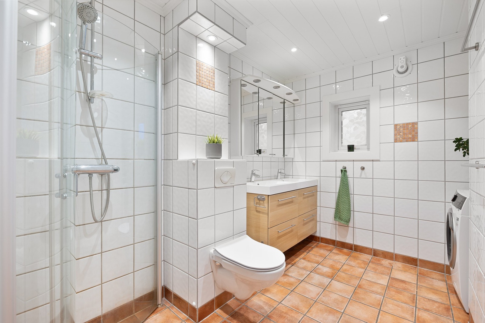 Pent flislagt bad på 5,7 kvm med elektrisk gulvvarme og downlights i taket. Galleribilde