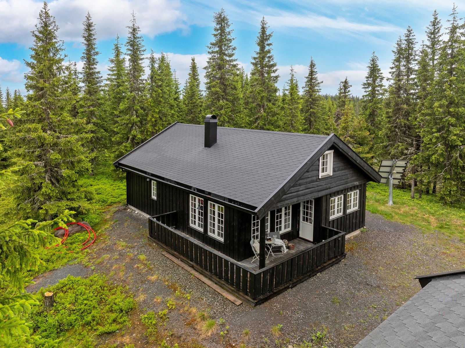 Hytta ligger i et småkuppert terreng. Galleribilde