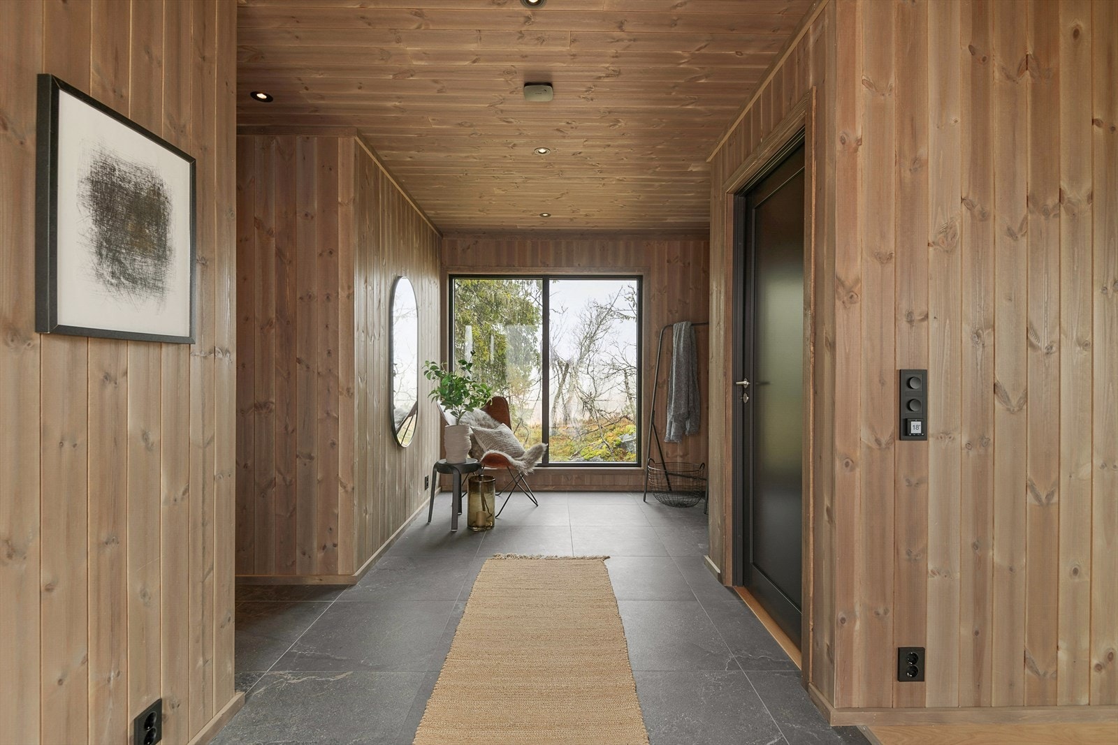 Romslig gang med fliser som har gullvarme og god plass til å henge fra seg yttertøy og utstyr. Galleribilde