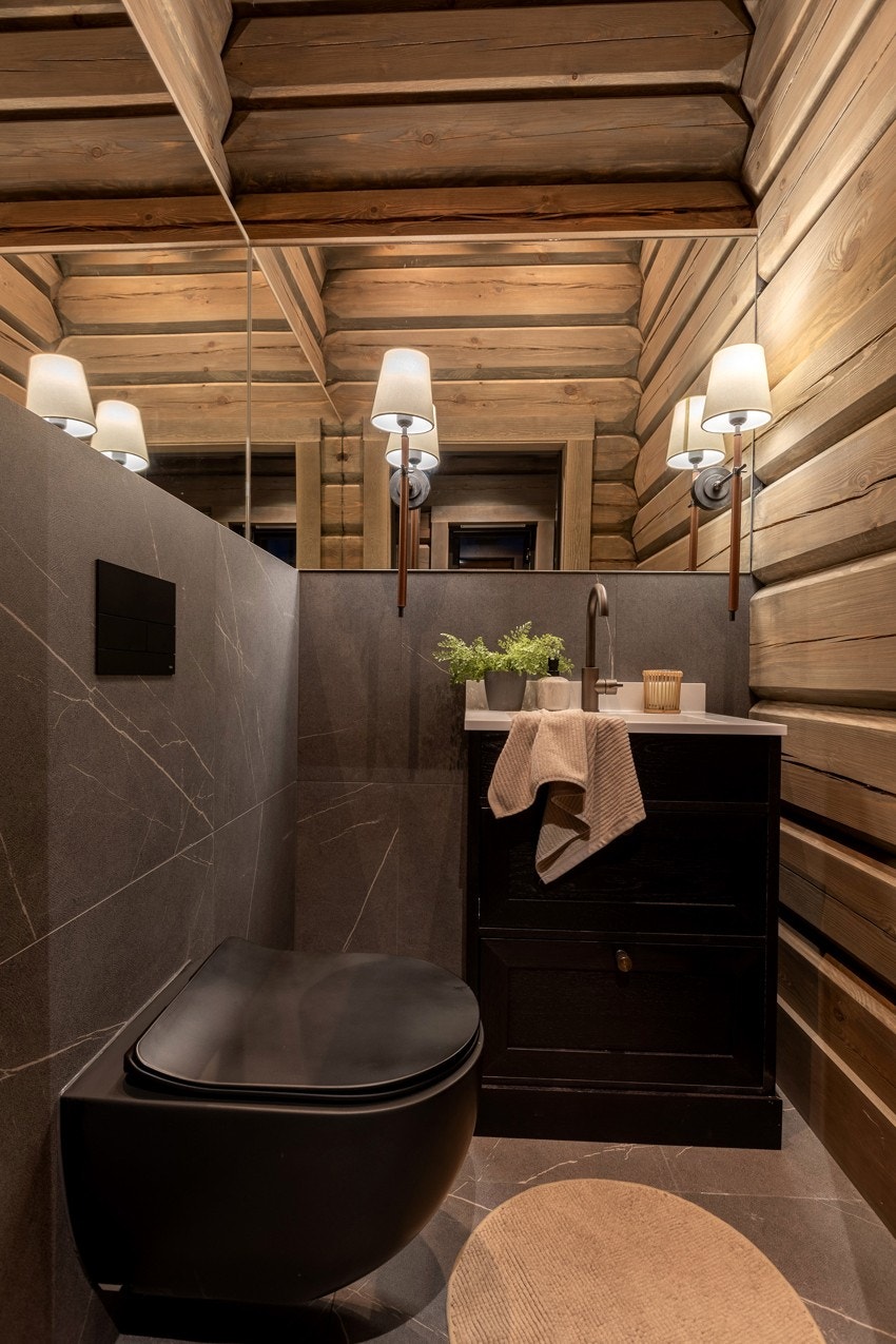 Toalettrommet er utstyrt med vegghengt toalett med innebygd sisterne, samt servant med servantskap i beisede trefronter Galleribilde