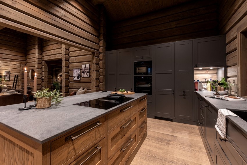 Benkeplaten er i stein, og løsningen er utstyrt med integrerte hvitevarer som kjøl/fryseskap, oppvaskmaskin, innebygd komfyr og mikrobølgeovn i høyskap Galleribilde