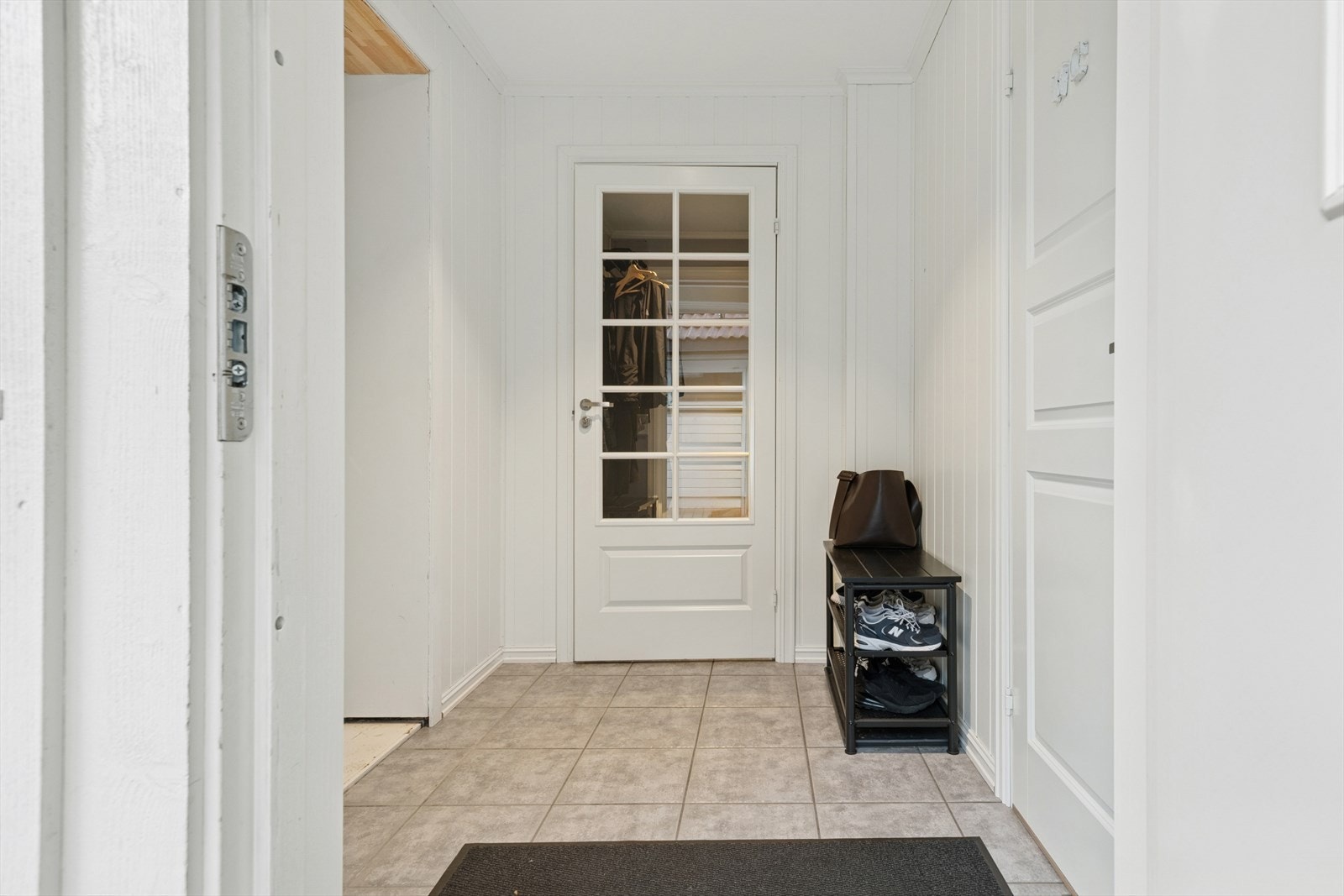 Her ønskes du velkommen inn i en flislagt entré med plass til å henge fra seg ytterklær. Galleribilde