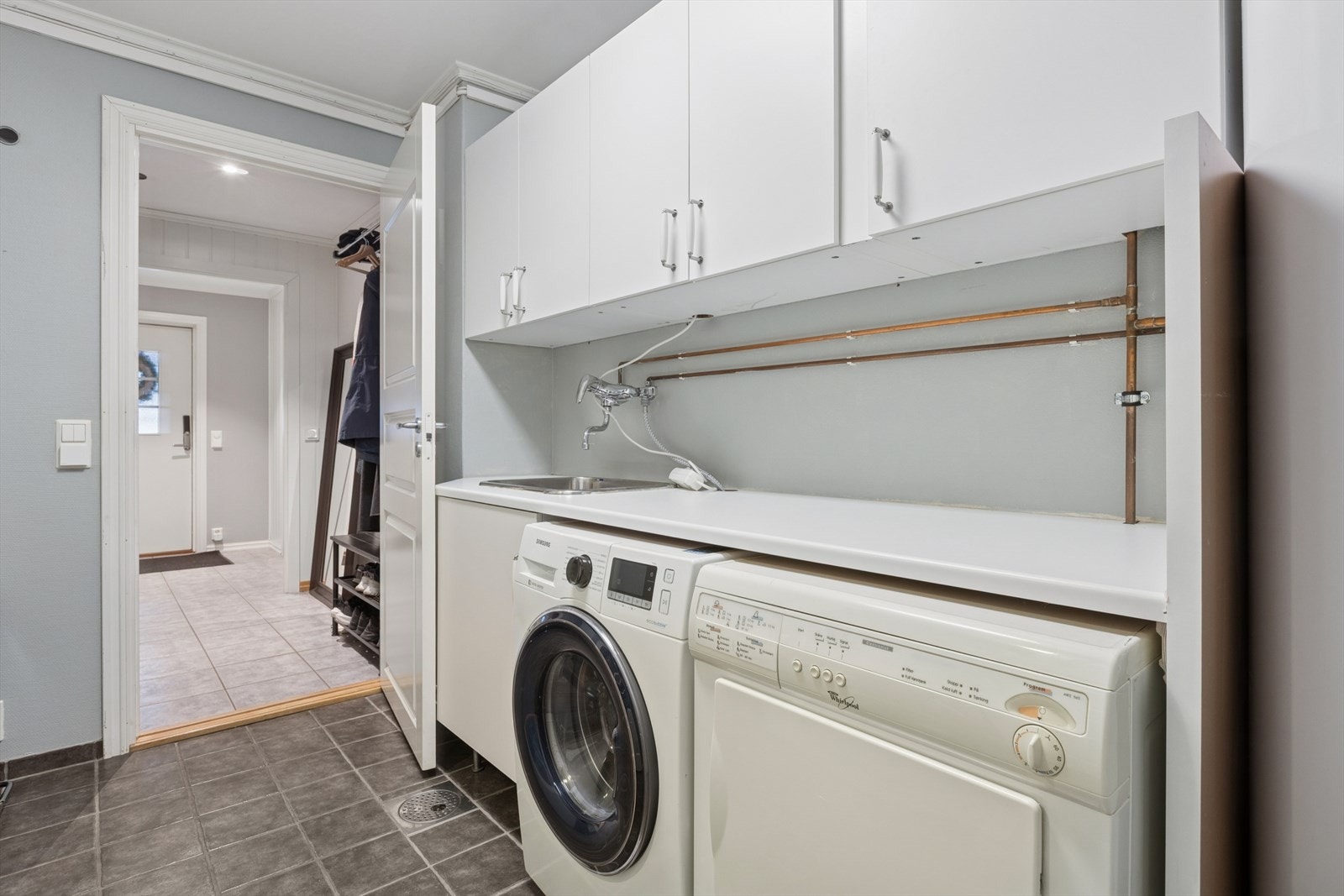 Vaskerommet er flislagt med varme i, utstyrt med innredning, laminat benkeplate, utslagskum og opplegg for vaskemaskin. Galleribilde