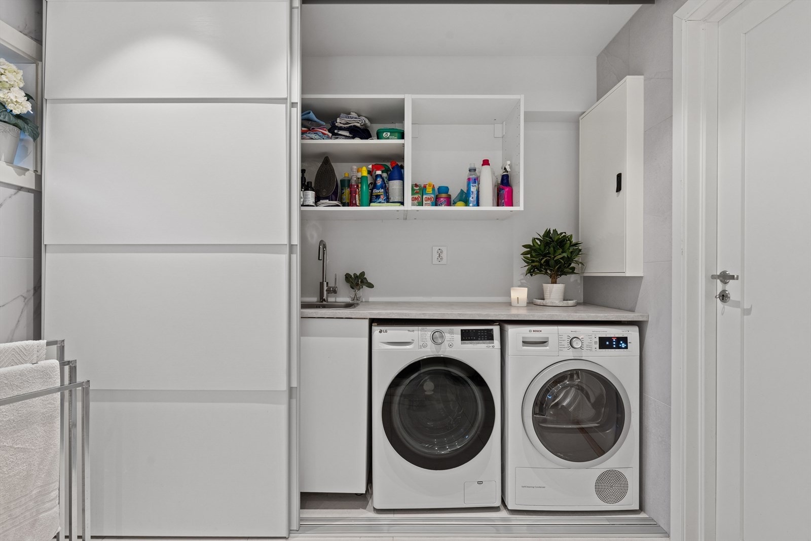 Badet har opplegg for vaskemaskin og tørketrommel som man enkelt kan gjemme bort med å dra for skyvedørene. Galleribilde