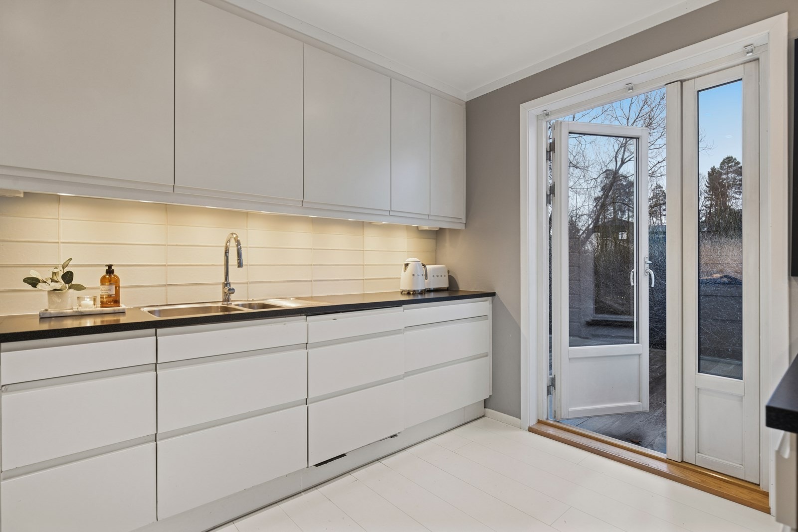 Kjøkkenet har i tillegg en tofløyet dør fra 2013 ut mot terrasse og hage, noe som gjør det enkelt å ta med måltidene ut på varme dager. Galleribilde