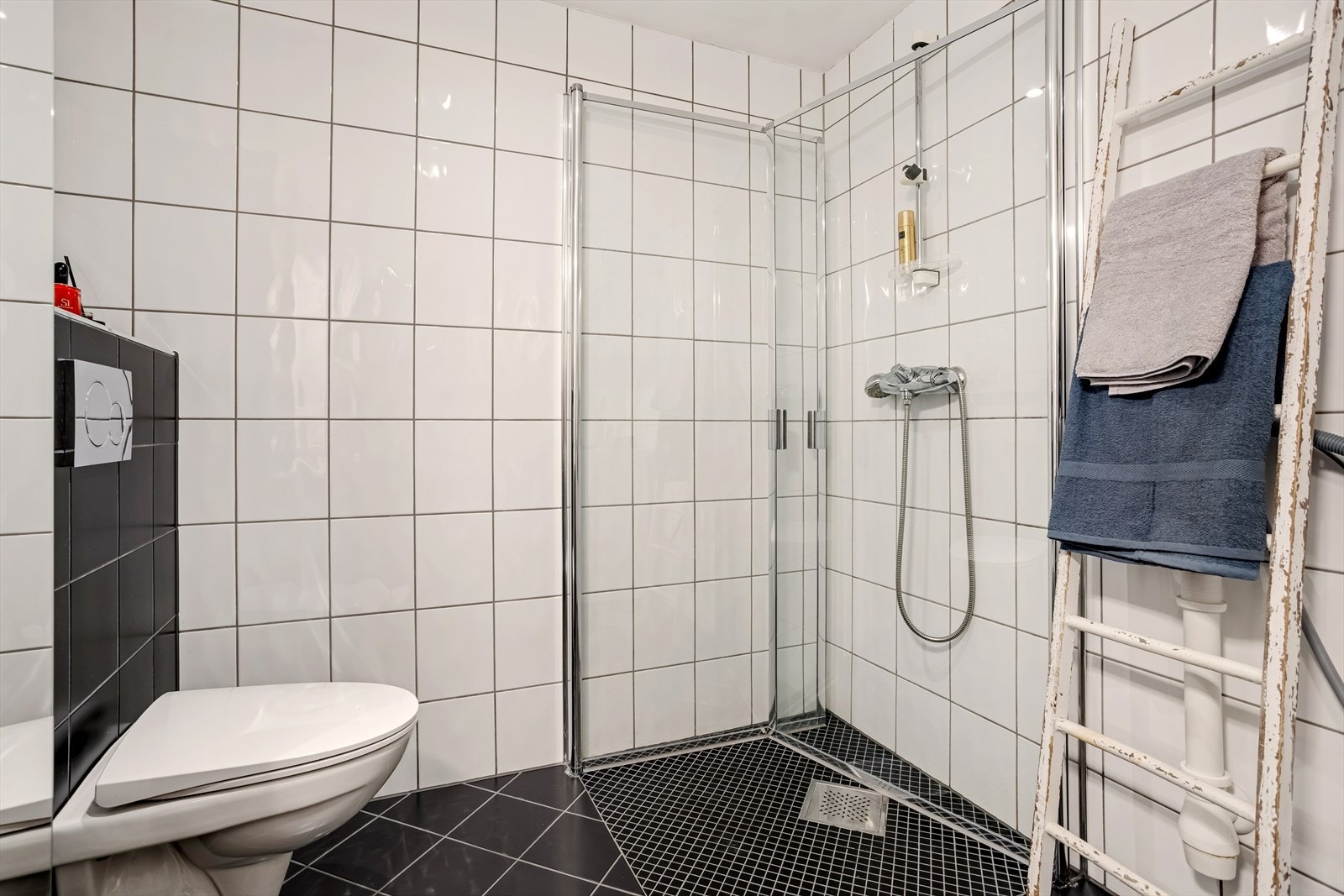 Dusjhjørne, vegghengt toalett og varmekabler i gulv. Galleribilde