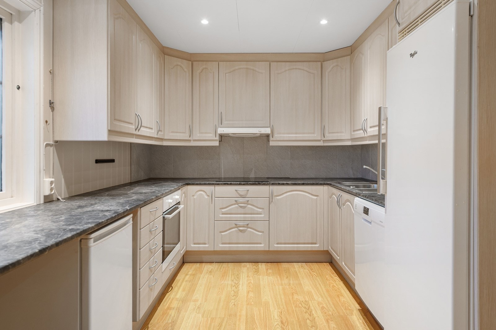 Plassrikt kjøkken med god skap og benkeplass. Dels integrerte og frittstående hvitevarer. Galleribilde