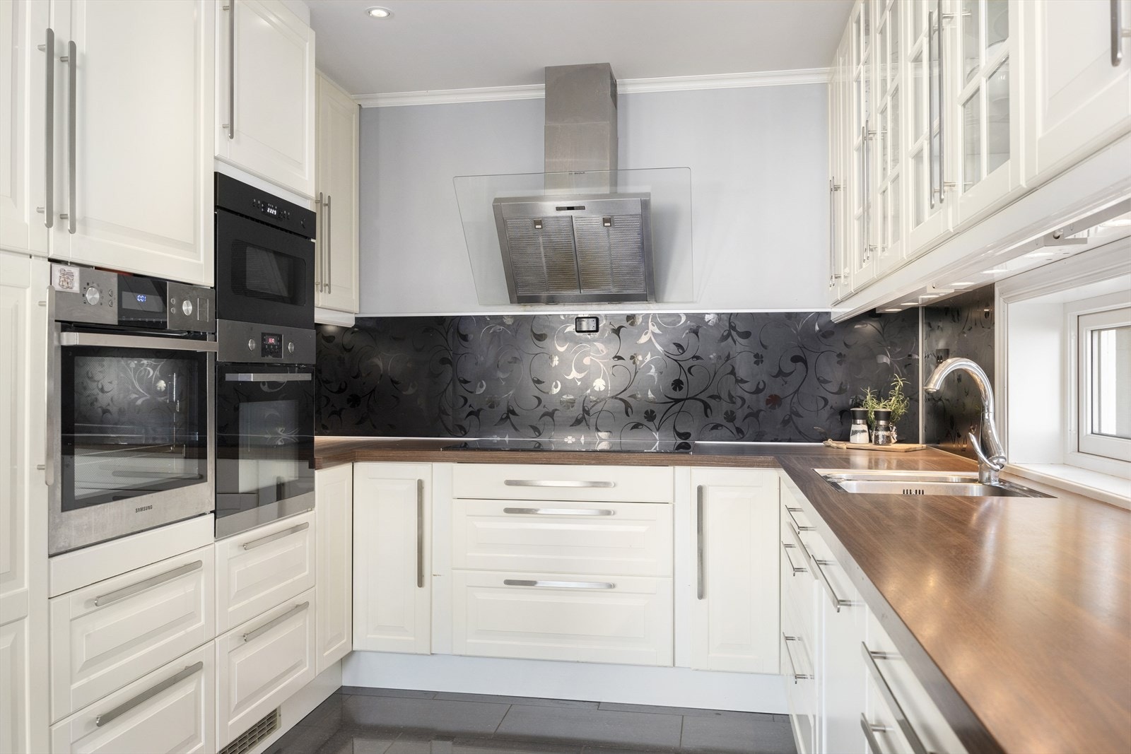 Integrerte hvitevarer som blant annet inkluderer 2-delt kjøleskap, stekeovn med dampfunksjon, mikro, koketopp og oppvaskmaskin gjør kjøkkenet både funksjonelt og oppdatert. Dette er et sted hvor matlaging blir en ren fornøyelse. Galleribilde