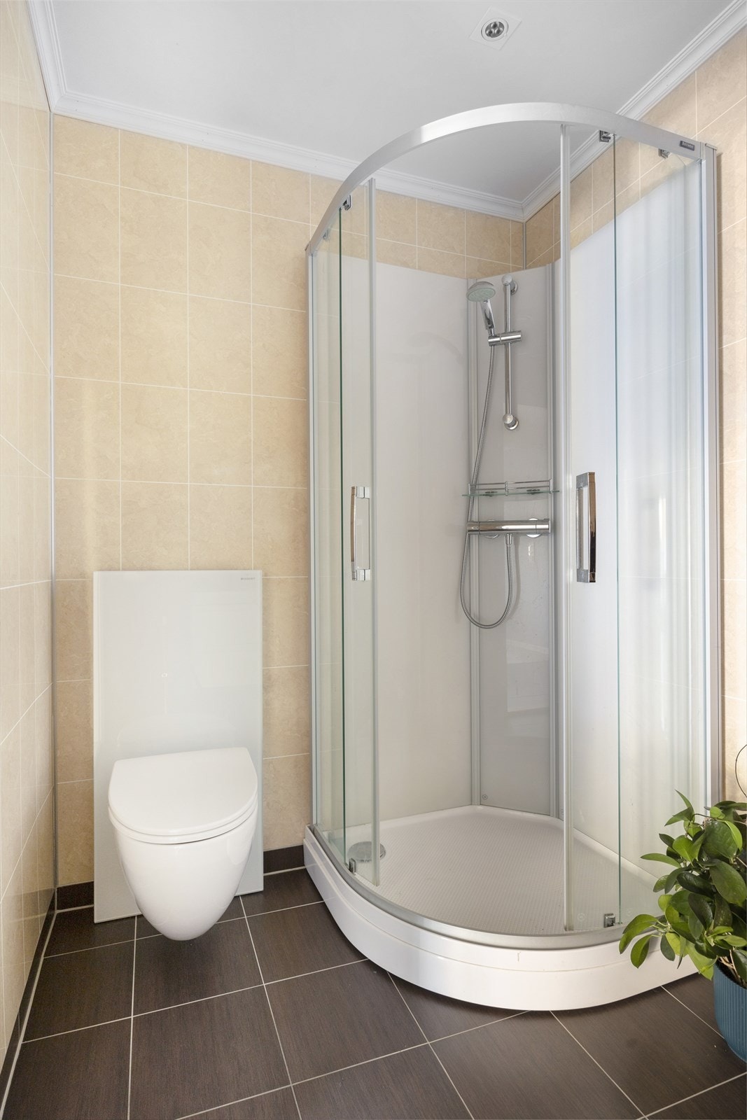 Badet i første etasje har servant nedfelt i benkeskap, veggskap, speil med lys, vegghengt Monolith toalett og dusjkabinett. Galleribilde