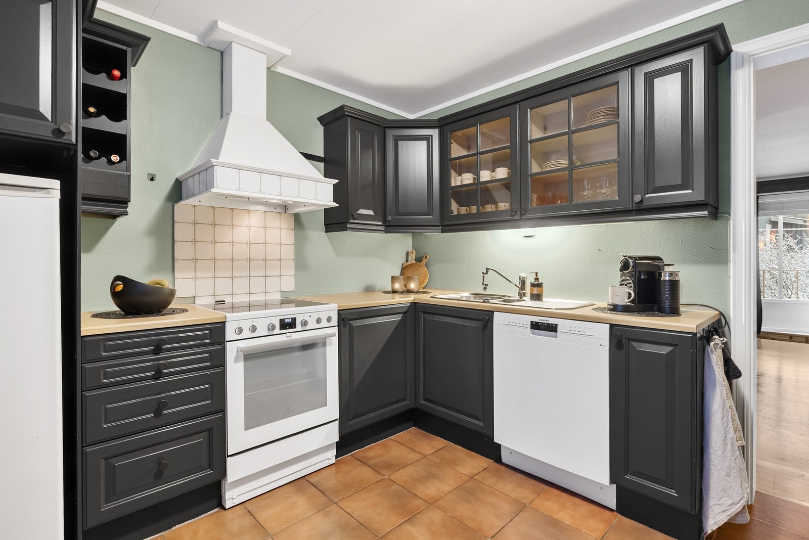 Kjøkkeninnredning med malte profilerte fronter av tre og benkeplate av laminat Galleribilde