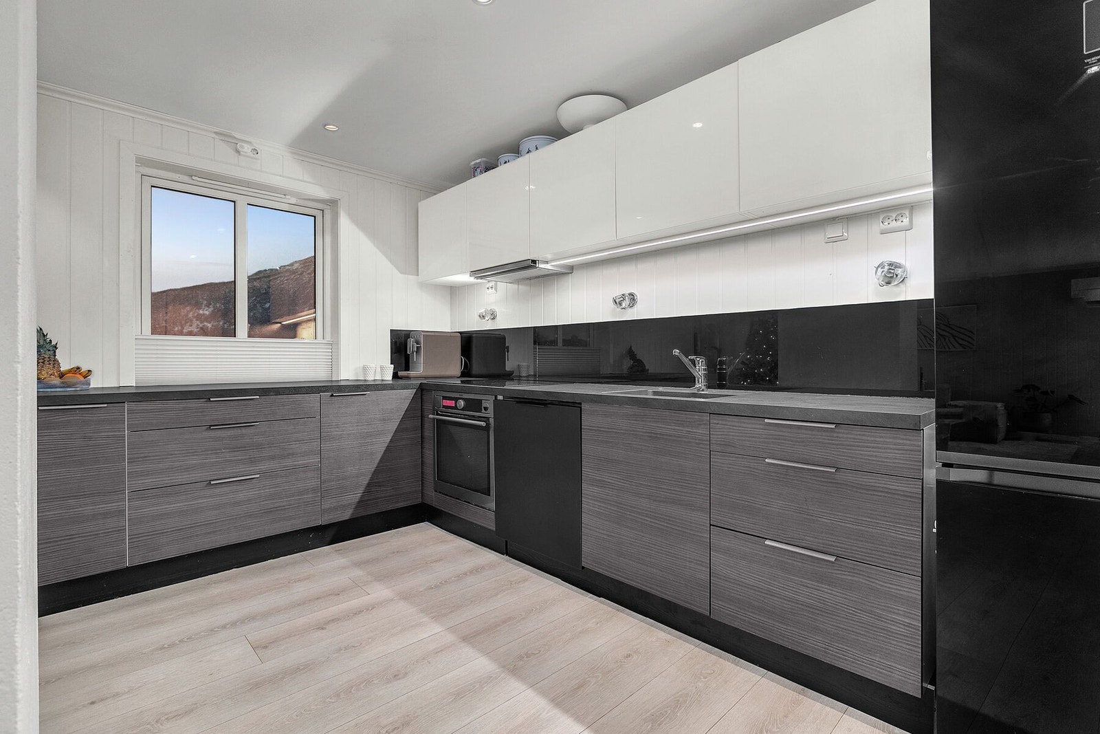 Pent kjøkken med godt med benkeplass og integrerte hvitevarer Galleribilde