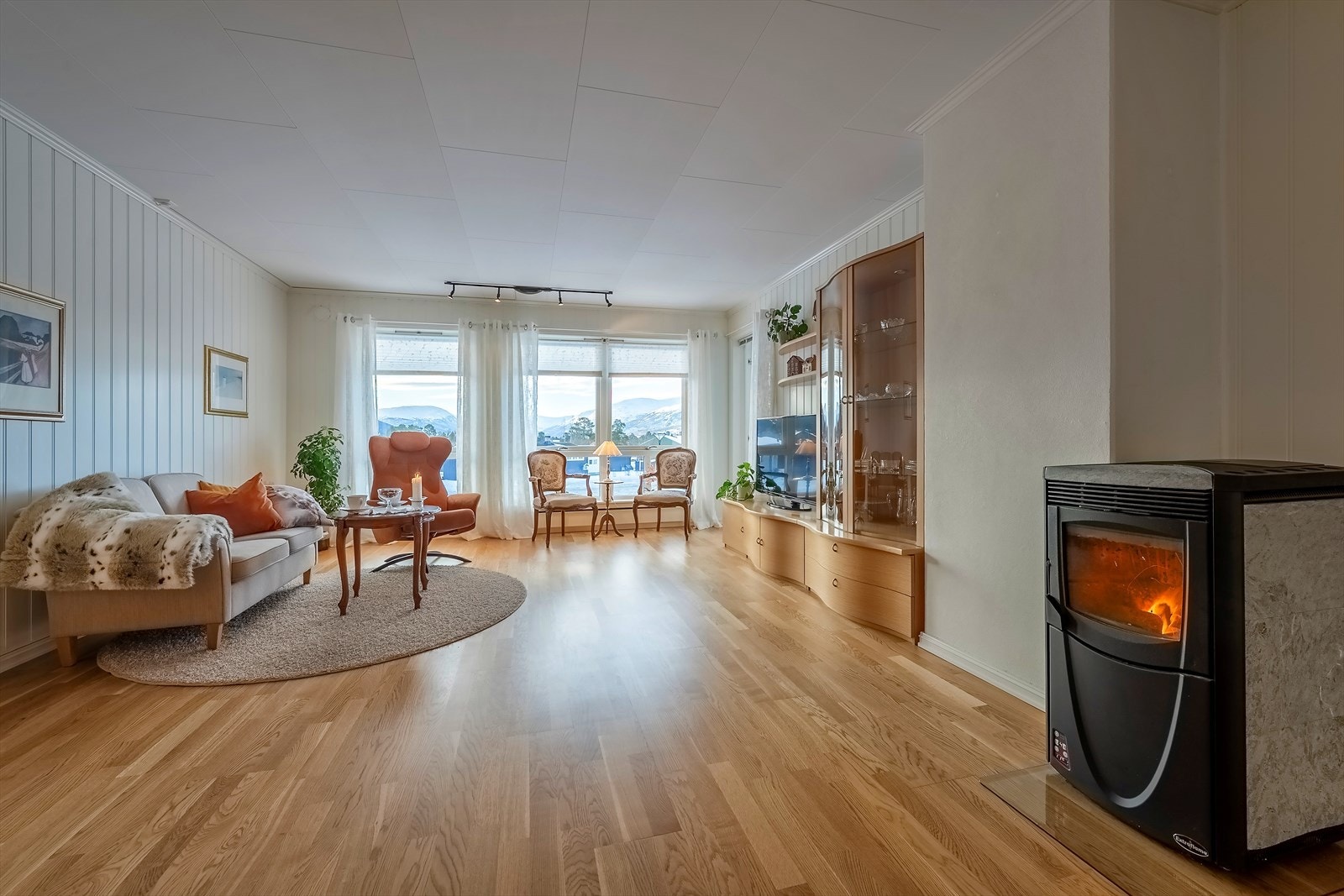 Stue med pelletskamin og store vindusflater mot sør Galleribilde