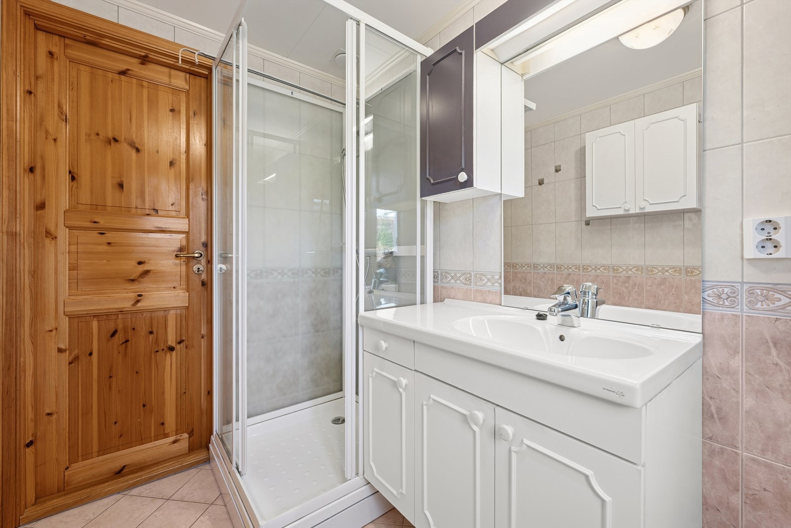 Badet inneholder baderommsinnredning og dusjkabinett. Det er varmekabler på gulv. Galleribilde