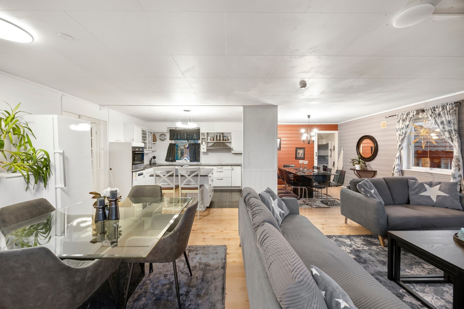 Romslig stue med god plass til flere sittegrupper Galleribilde