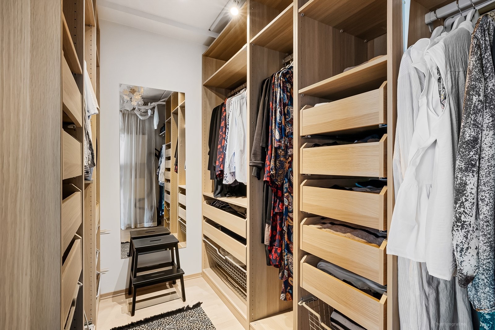 Garderoberommet er praktisk innredet med garderobeskap som innehar både skuffer, hyller og heng. Galleribilde