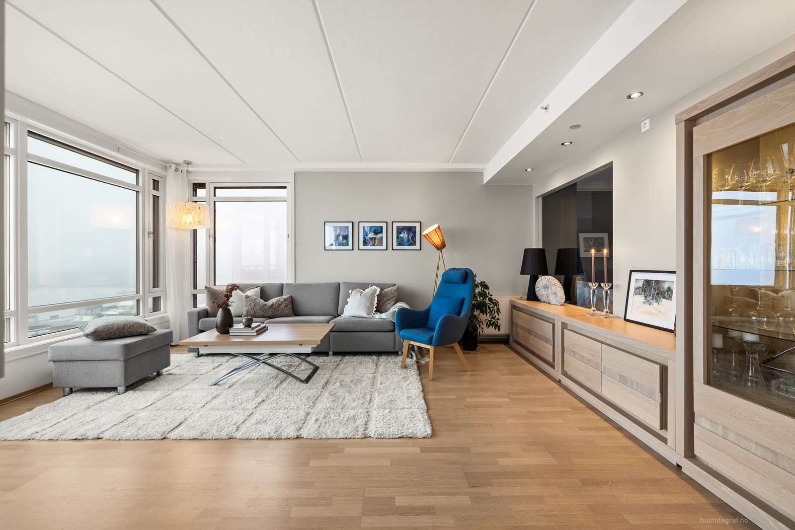 Stue med store vindusflater som gjør rommet lyst og innbydende. Det er utstrakt bruk av downlights i himling. Galleribilde