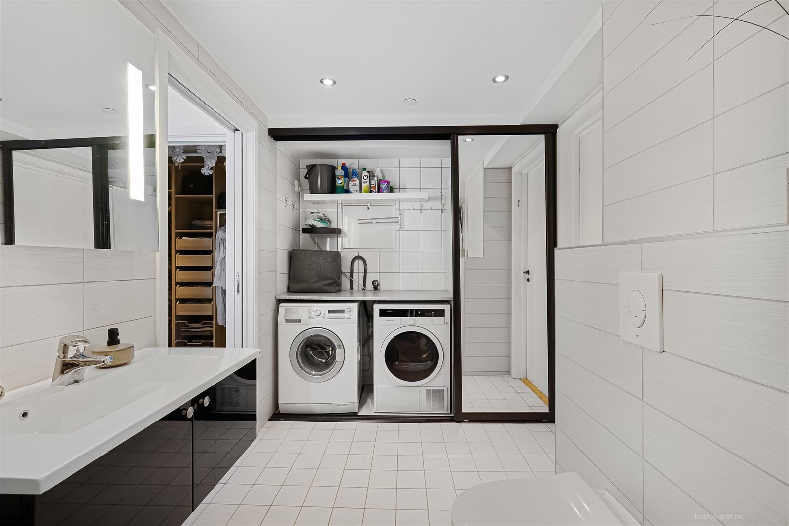 På badet er det praktiske skyvedører som effektivt skjuler vaskemaskinen, tørketrommelen samt fryseskap. Galleribilde