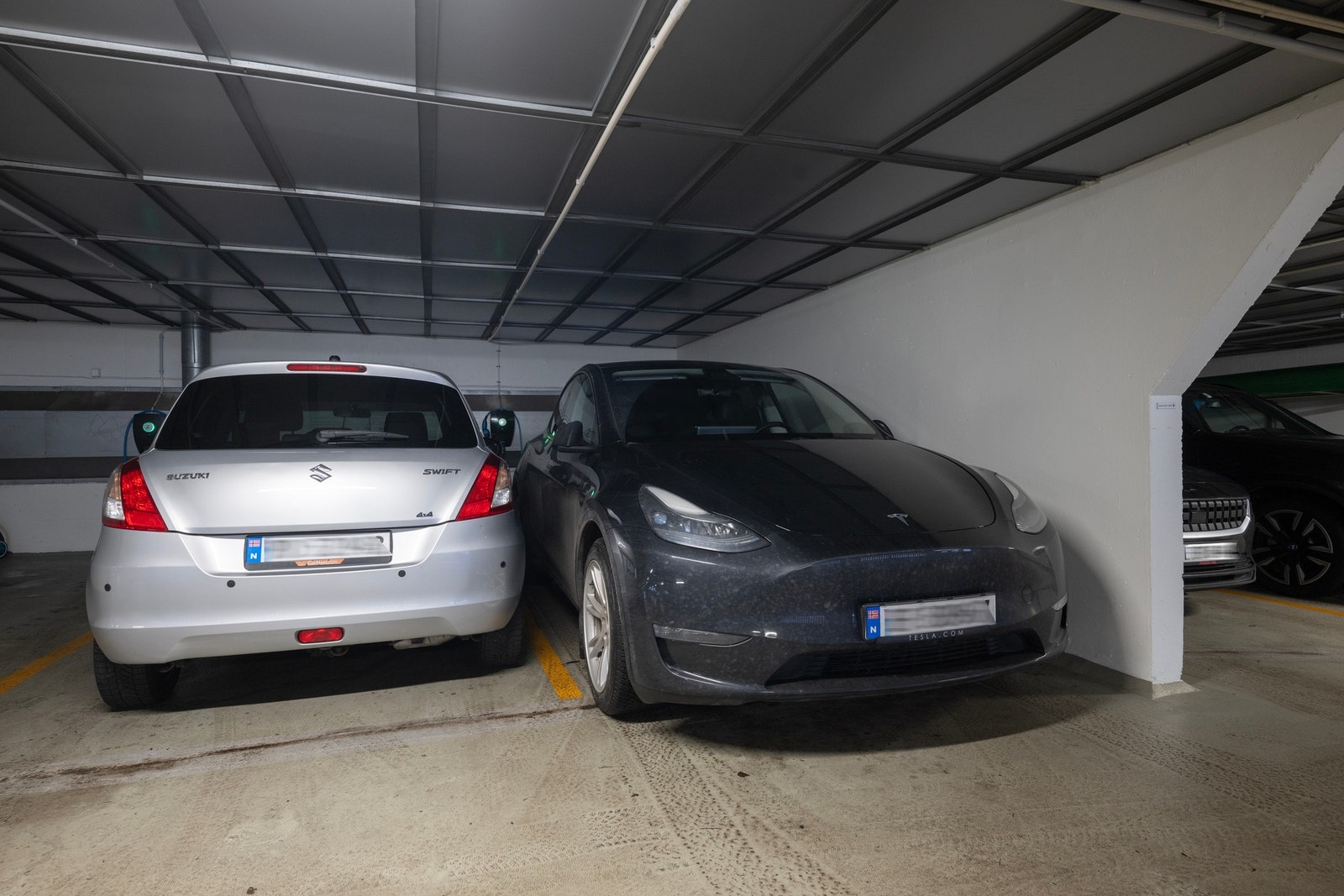 Det medfølger garasjeplass i felles anlegg. Det er installert ladeboks for elbil (plass helt til høyre i bildet). I tillegg tilgang til to sykkelboder, en for egen oppgang og en felles for blokka. Galleribilde