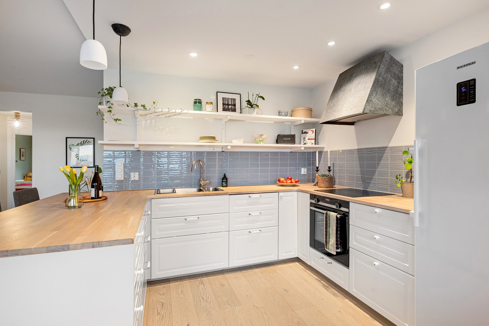 Kjøkkenet har et stilrent uttrykk med integrerte hvitevarer som medfølger i salget. Frittstående kjøleskap medfølger også. Galleribilde