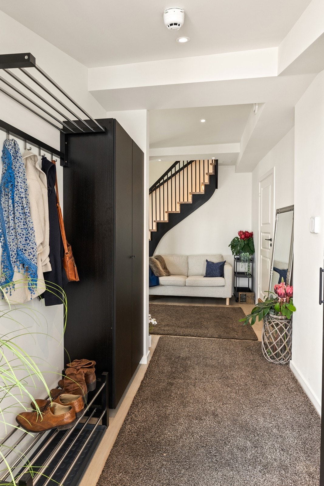 Velkommen inn i en lys entré med oppsatte garderobeskap og skohylle Galleribilde