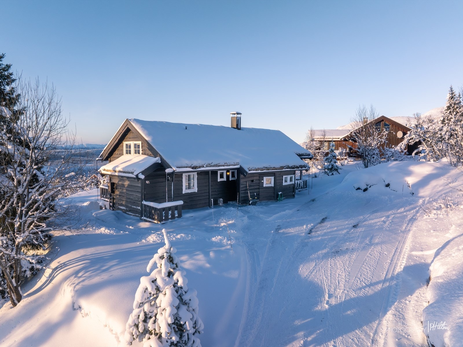 Gårdsplassen rommer ca 5 biloppstillingsplasser. Elbillader montert 2024 på hytteveggen Galleribilde