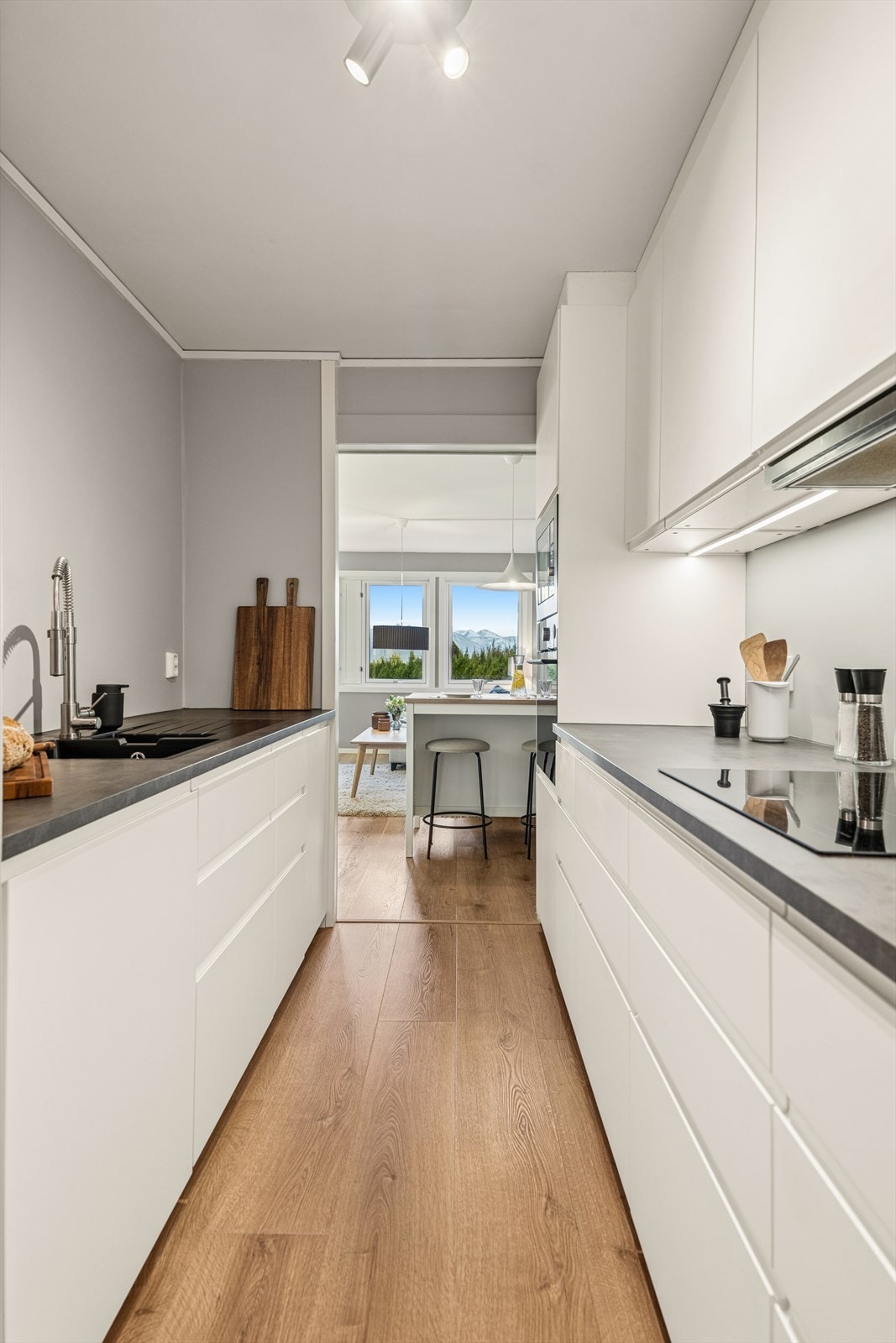 Kjøkkenet fremstår stilrent, pent og praktisk. Gjennomgående gulv fra kjøkken til stue. Galleribilde