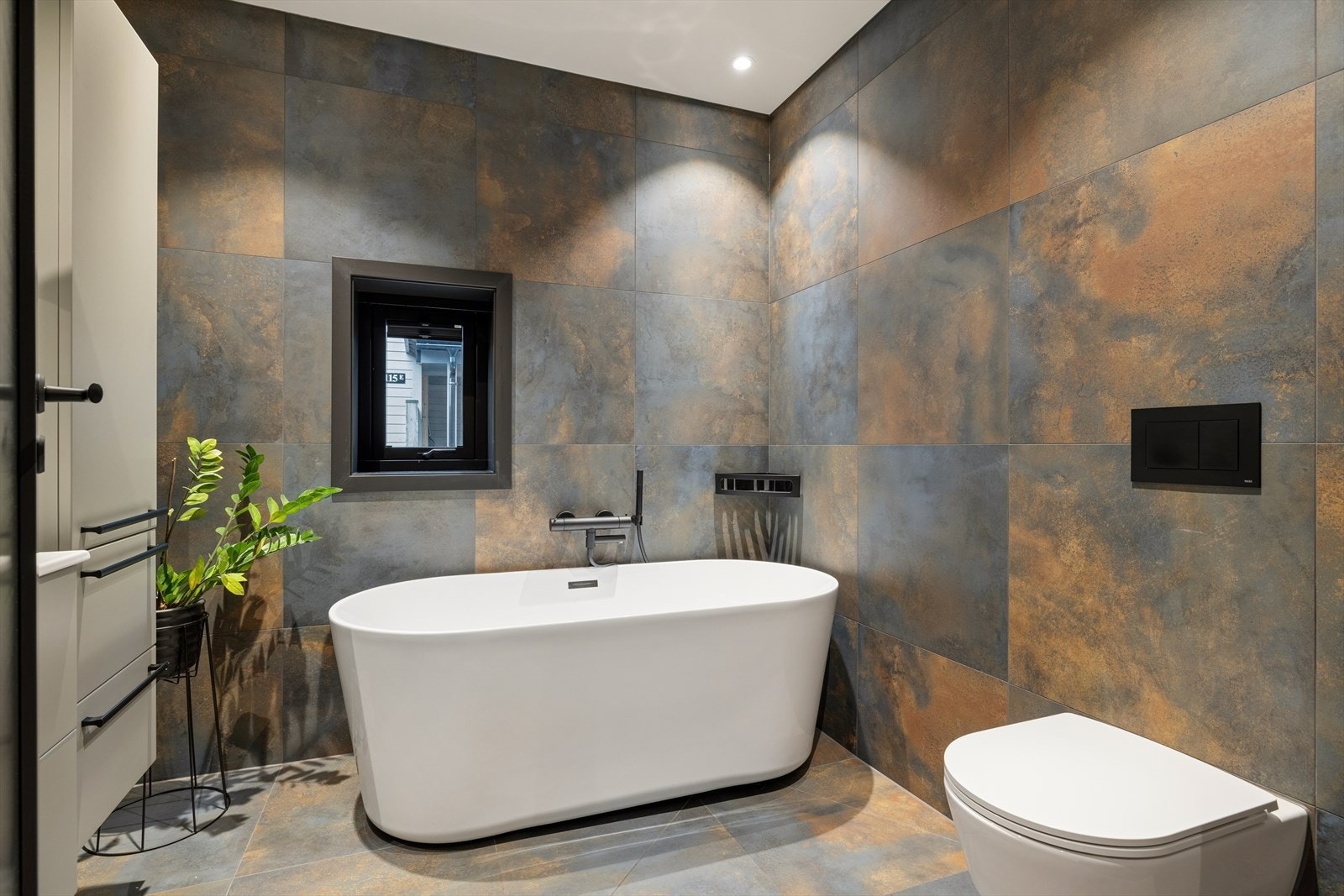 Flott baderom med badekar og veggmontert toalett. Galleribilde