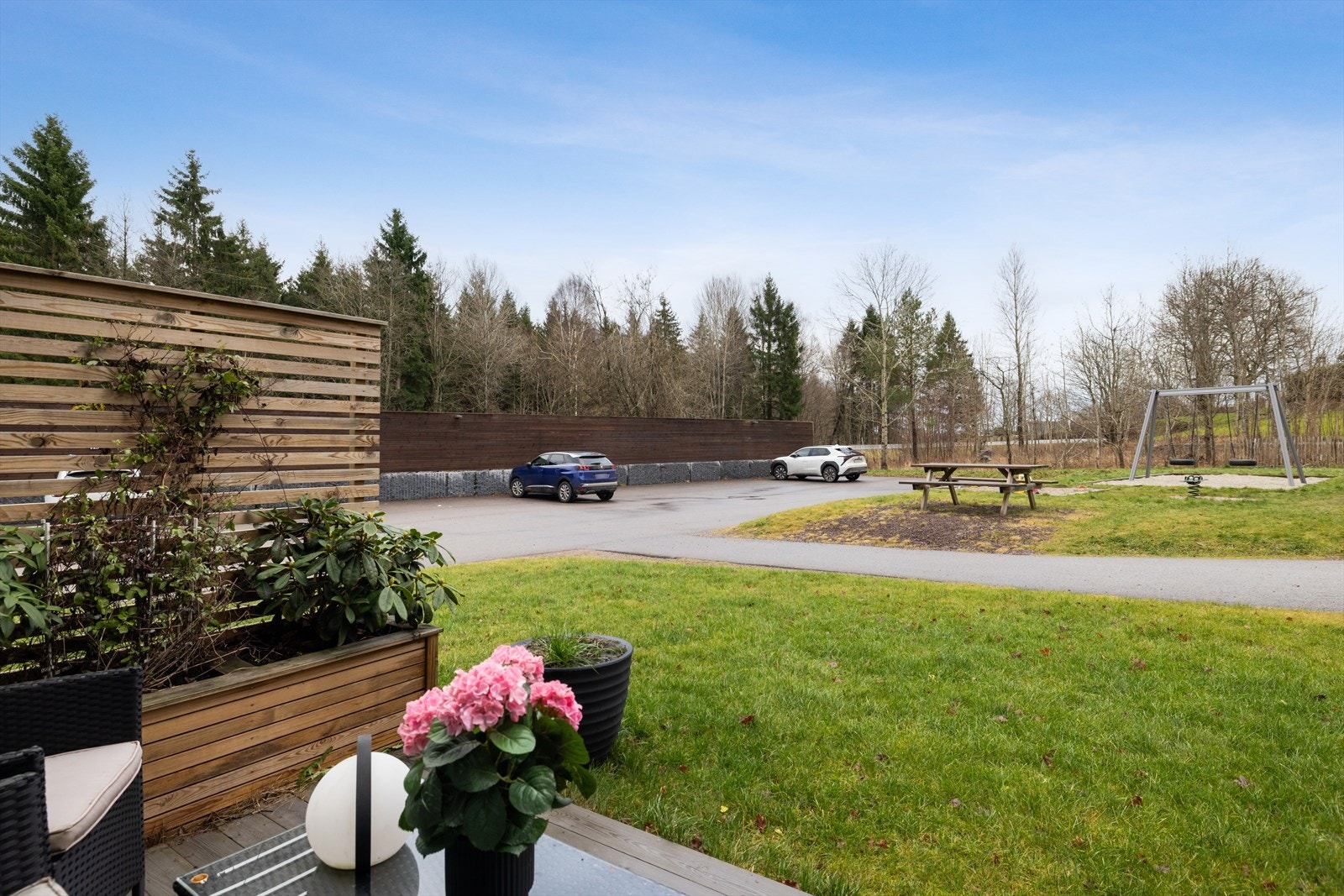 Fellesareal med parkering, sitteplasser og lekeområde, et sted for både lek og samvær. Galleribilde