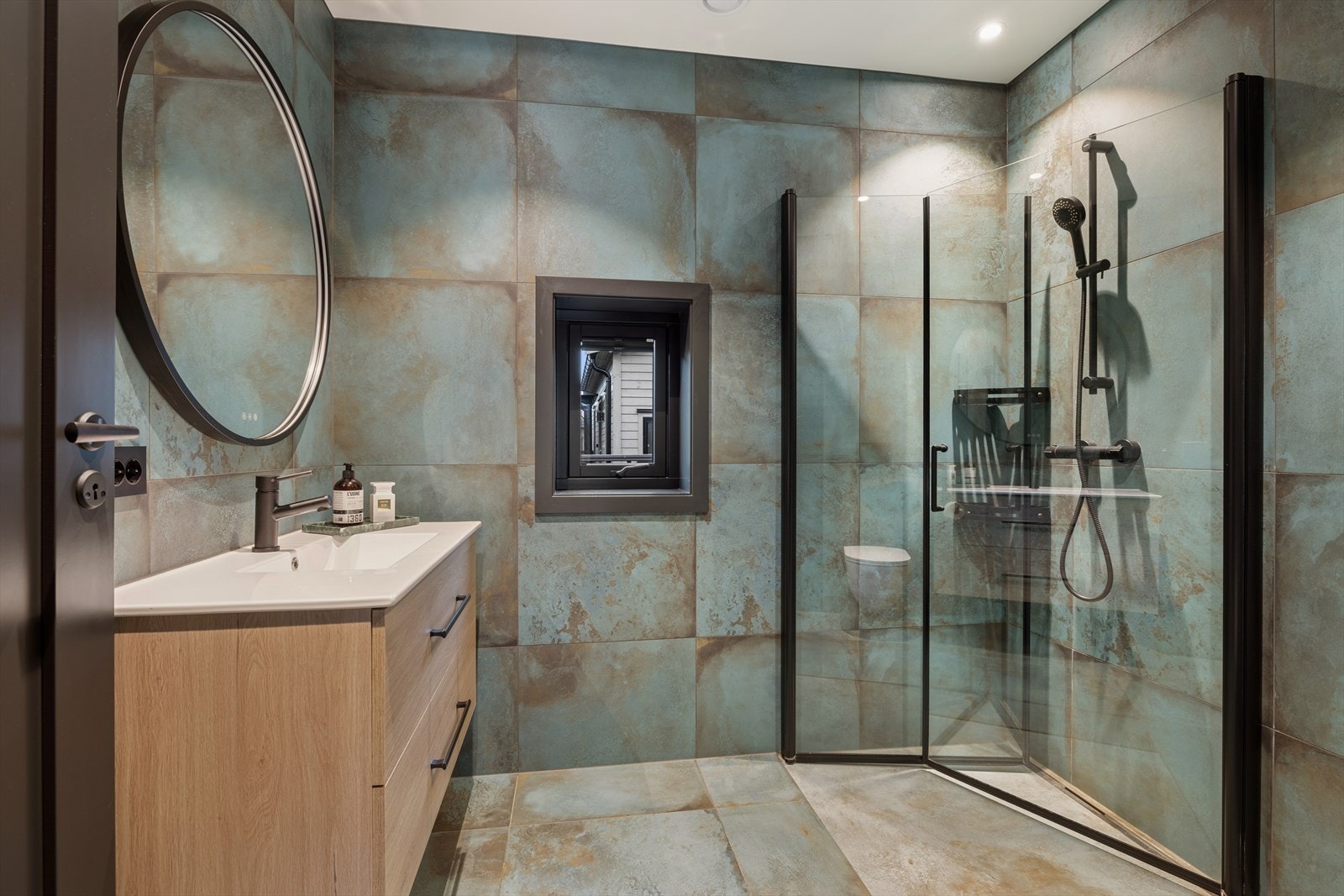 Delikat baderom som har innredning med nedfelt servant og dusjvegger/hjørne. Galleribilde