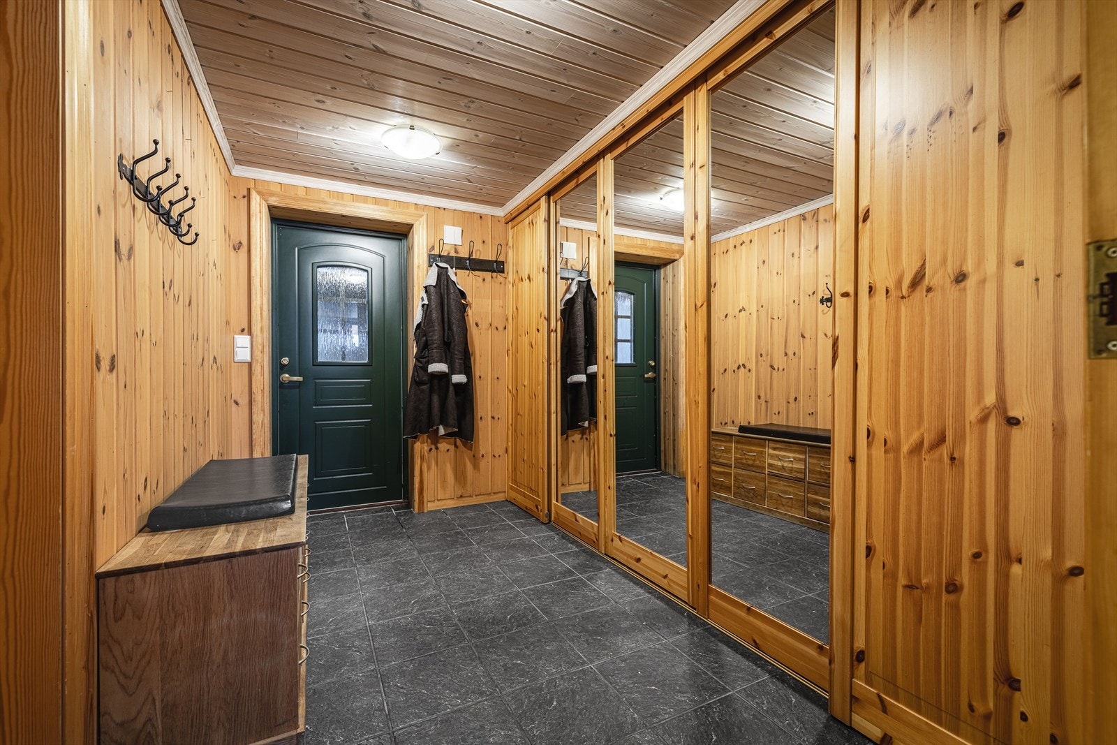 Romslig gang med skyvedørsgarderobe og flislagt gulv i separat innredet del. Galleribilde