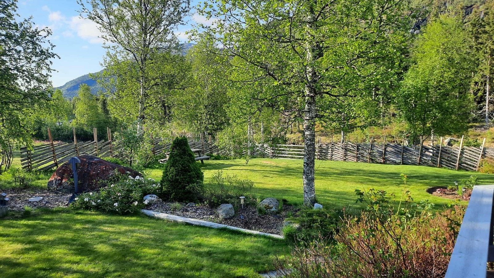 Flott opparbeidet hage med blomsterbed og busker. Galleribilde