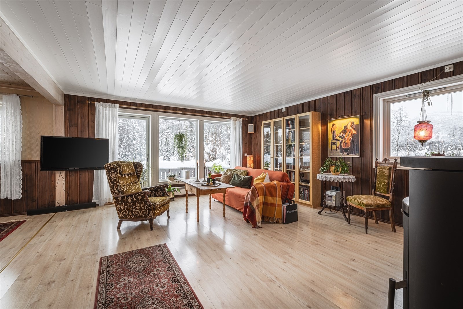 Romslig stue med store vindusflater som rammer inn fjellandskapet. Galleribilde