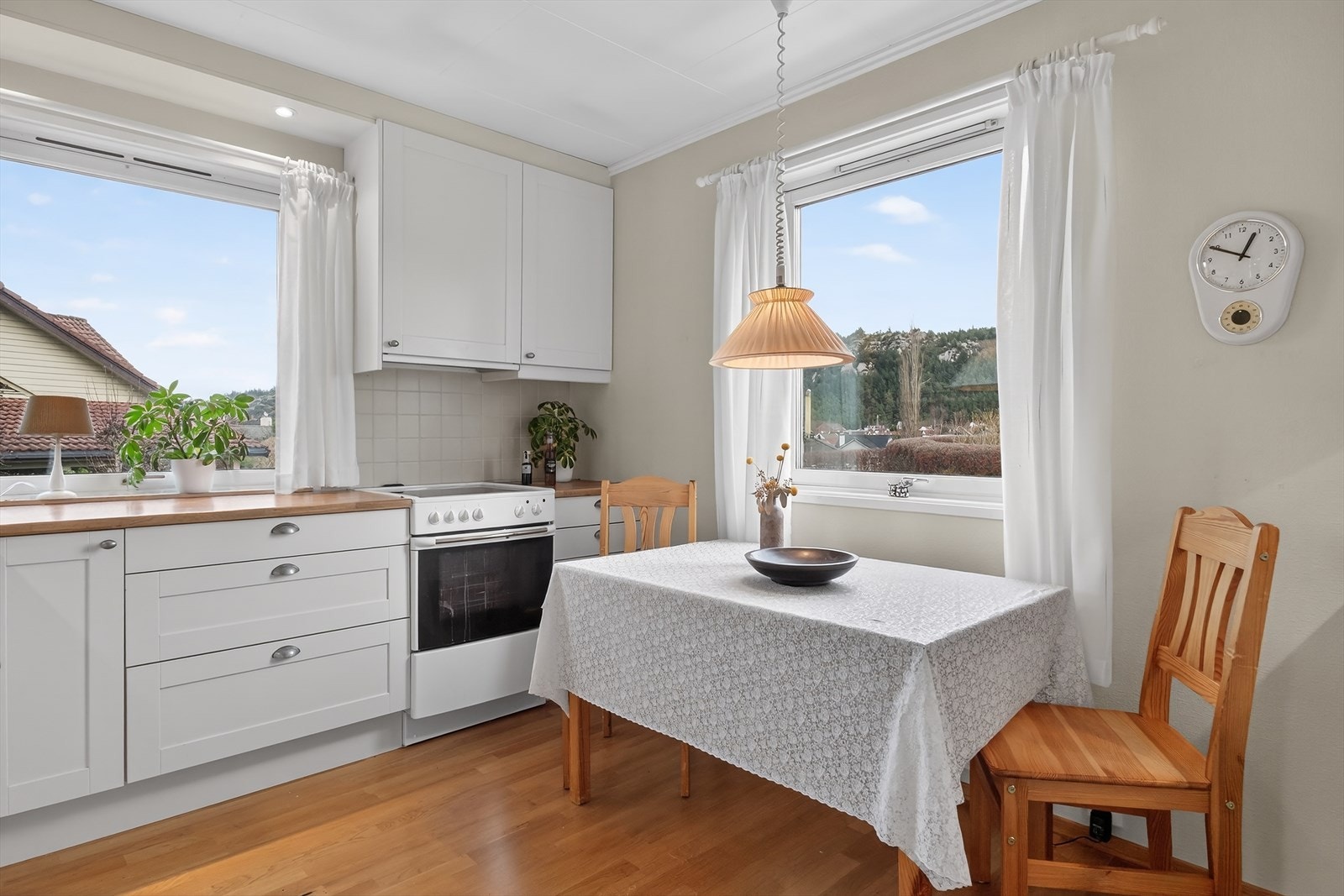 Pent kjøkken med trivelig spiseplass ved vinduet Galleribilde