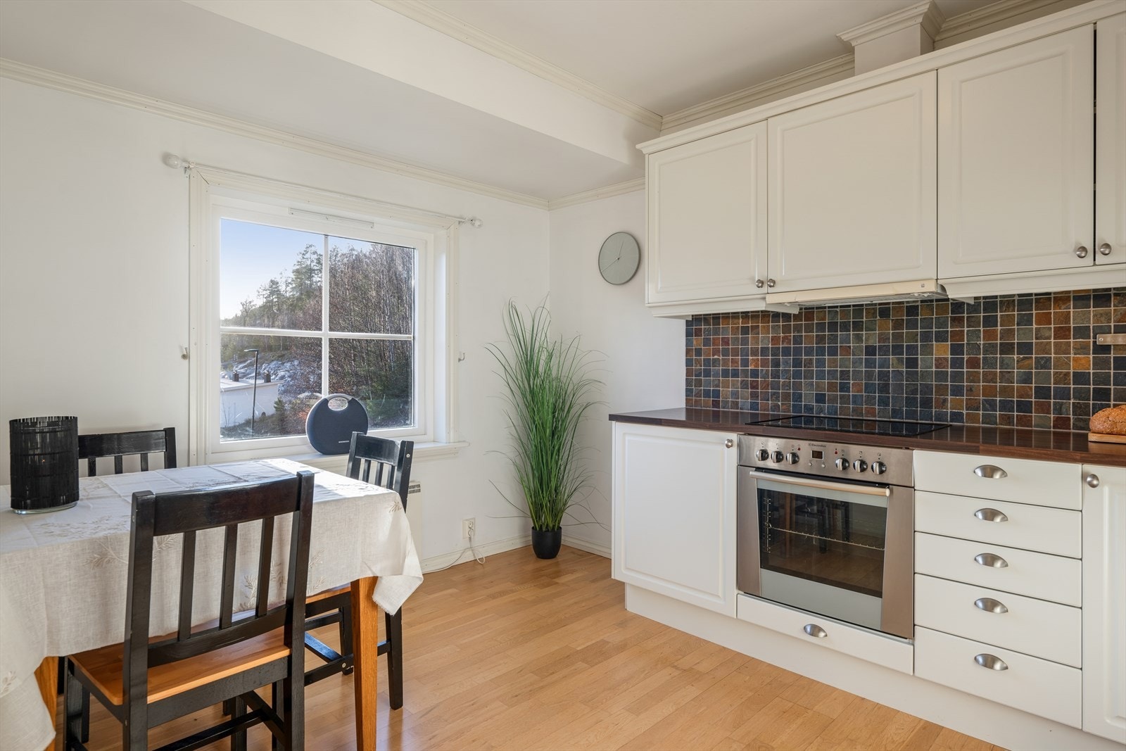 Kjøkkenet har profilerte fronter, fliser mellom over- og underskap og laminat benkeplate. Galleribilde